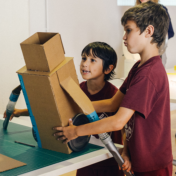 Two young boys with their prototype made from cardboard and Dyson vacuum cleaner parts.