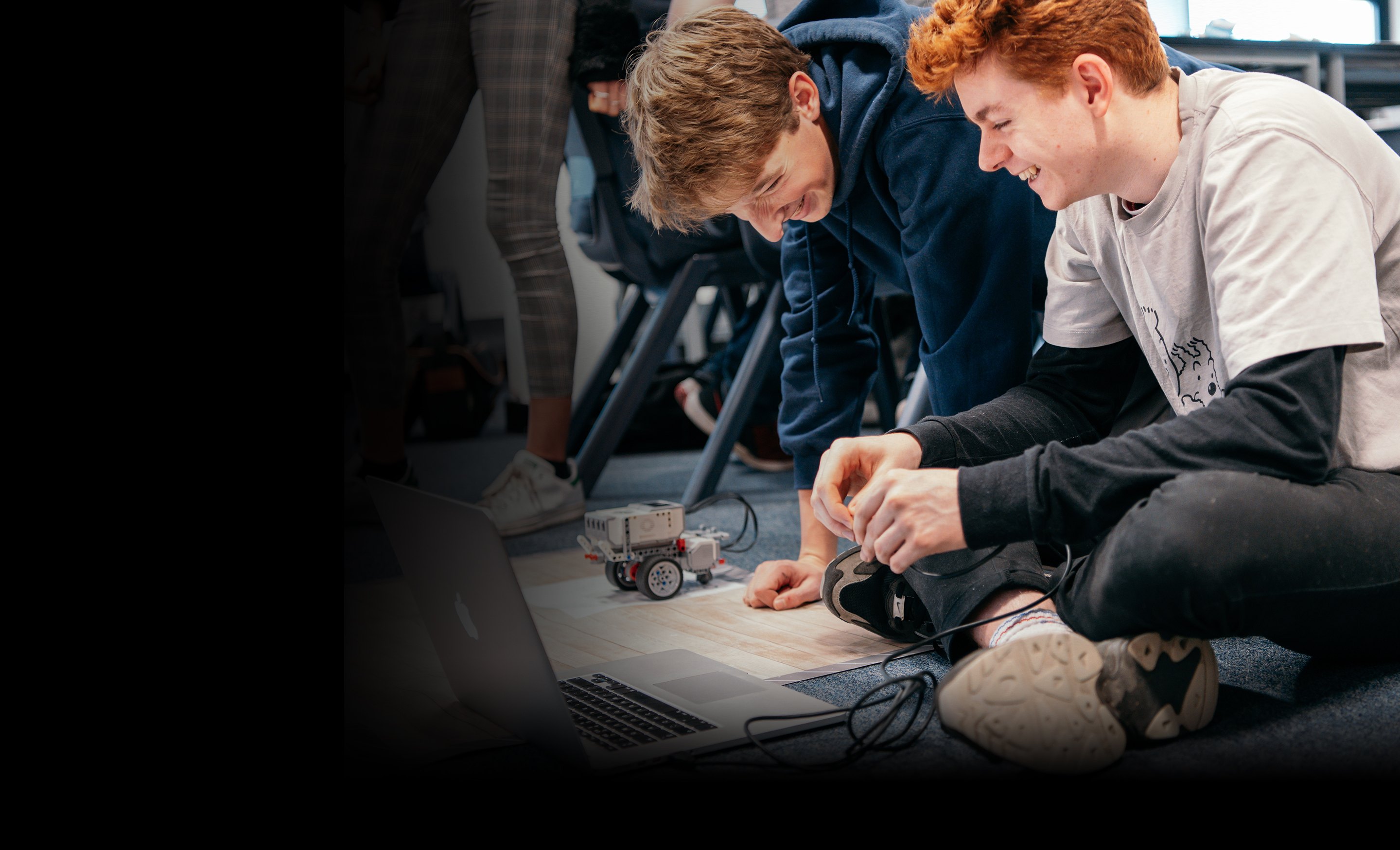 Two students programming a Lego Mindstorms robot in a James Dyson Foundation robotics workshop.