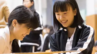 Two students using cardboard to build a prototype.