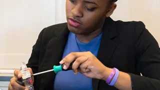 A student disassembling a vacuum cleaner machine head.