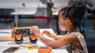 A student building a prototype from cardboard.