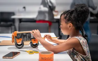 A student building a prototype from cardboard.