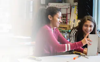 Two students building a prototype from cardboard.