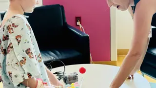 A child getting hands-on with the Floating Ping Pong Balls Challenge Card at Lurie Children's Hospital of Chicago.
