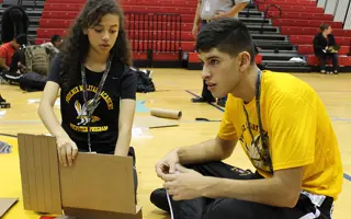 Two students building a prototype from cardboard.