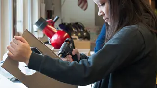 A student building a prototype from cardboard.