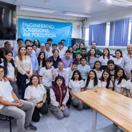 Students and teachers from a school in Mexico City grouped together in front of a banner that says 'Engineering Solutions: Air Pollution'.