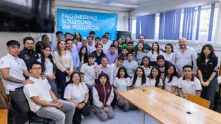 Students and teachers from a school in Mexico City grouped together in front of a banner that says 'Engineering Solutions: Air Pollution'.
